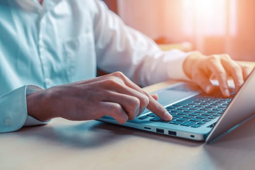 Businessman hand typing on computer keyboard of a laptop computer in office. Business and finance concept. uds