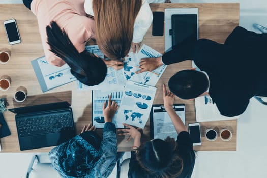 Top view of businessman executive in group meeting with other businessmen and businesswomen in modern office with laptop computer, coffee and document on table. People corporate business team uds