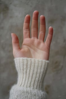 A person's hand with a white knit glove on it