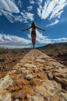 A woman walking on a path with her arms outstretched