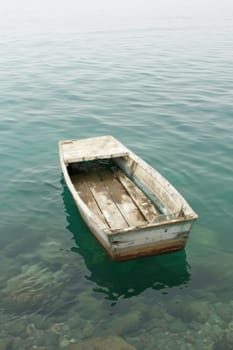 A small boat floating in the middle of a body of water