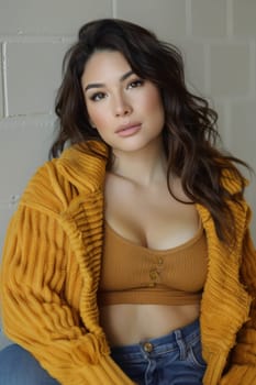 A woman in a yellow sweater and jeans posing for the camera