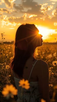 A woman standing in a field of flowers with the sun setting behind her
