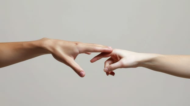 Two hands reaching for each other with a gray background