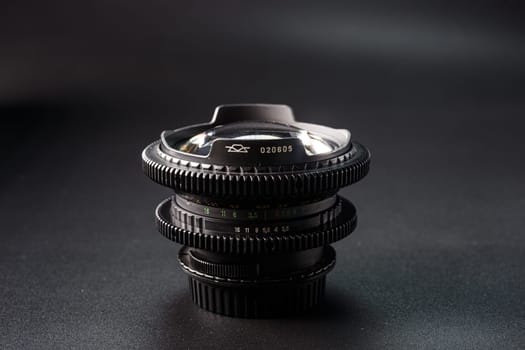 Layered antique camera lenses, serial number prominently displayed, capturing the essence of classic photography equipment, set on a dark surface.