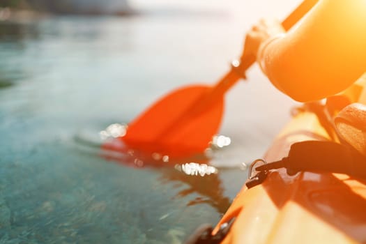 Kayak paddle sea vacation. Person paddles with orange paddle oar on kayak in sea. Leisure active lifestyle recreation activity rest tourism travel.