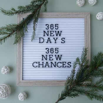 365 NEW DAYS 365 NEW CHANCES text on white letter board on green background with Christmas decor. New year aims resolutions. New year me concept