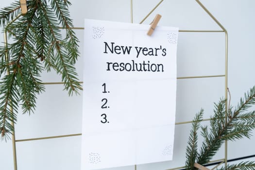 NEW YEAR'S RESOLUTION paper note on Dream board promises and aims. Preparation for new year new life new me. Visualizing wish list for 2025. Dreams plan action for coming year. Inspirational self improvement concept