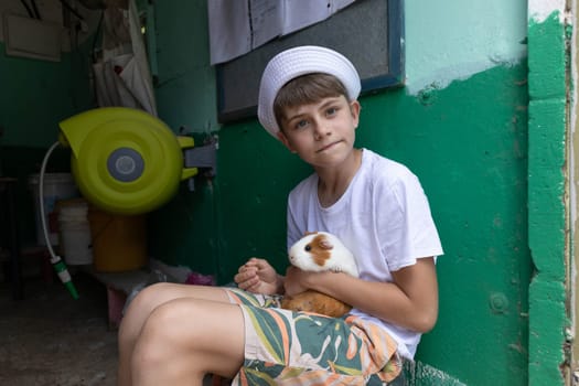 Boy holding a guinea pig in his arms. High quality photo