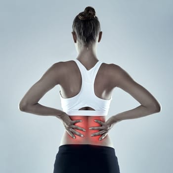 Exercise, injury and back pain, woman and red glow for spine x ray or bone isolated on grey background. Fitness, athlete and anatomy overlay with inflammation, muscle or tendon tension in studio.