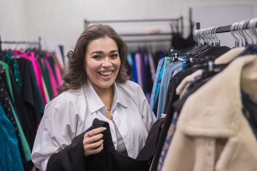 Portrait of a smiling fat woman choosing clothes in a plus size store