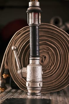 Emergency, equipment and pipe with fire hose for security, danger or health and safety at station. Closeup of gear, tools or pressure extinguisher ready for rescue, service or firefighting operation.