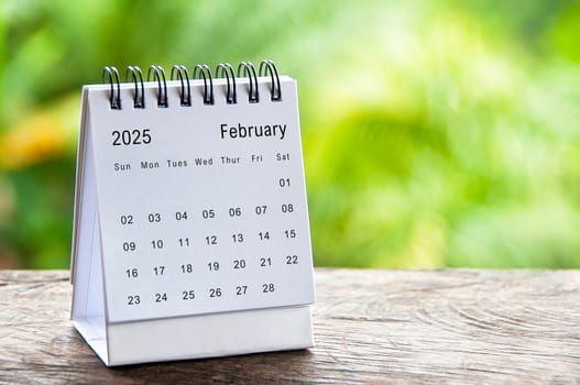 February 2025 white table calendar with customizable space for text. Calendar concept and copy space.