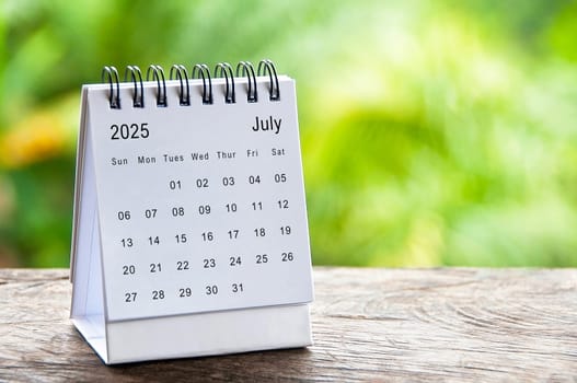 July 2025 white table calendar with customizable space for text. Calendar concept and copy space.