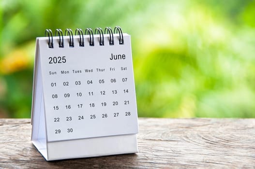 June 2025 white table calendar with customizable space for text. Calendar concept and copy space