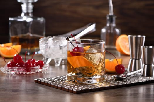 Cocktail Old Fashioned is an old-fashioned sophistication of whiskey and sweet syrup. Served with ice, orange zest and Maraschino cherry. 