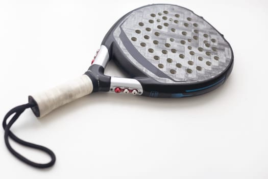 Set of paddle tennis rackets and balls the reflected on white table and white isolated background. Front view. High quality photo