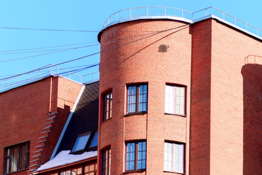 Brick building with numerous windows, creating a striking symmetrical pattern against the city skyline