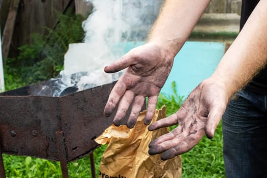 Dirty black hands covered in soot close up