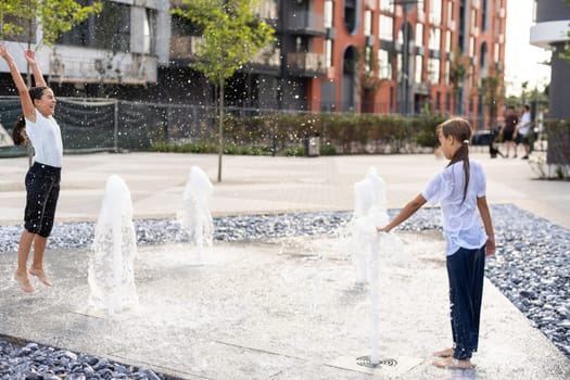 life of children in a modern city - little girl having fun with fountains. High quality photo