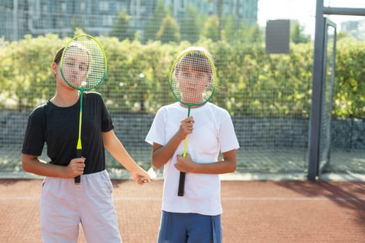 Two girls with badminton rackets on the football field. High quality photo