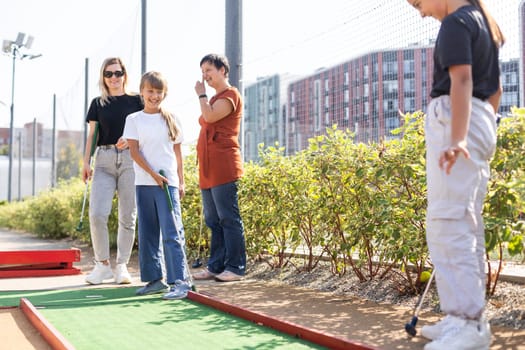 golfers with parents playing golf at sunny day. High quality photo