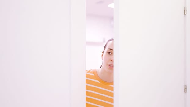 Woman peeping looking through a half-open door