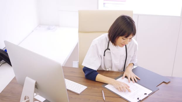 Female doctor consulting a medical report in her office