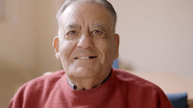 Old man smiling at camera sitting in a nursing home