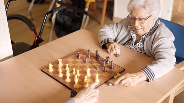 Two old women playing chess in a geriatric