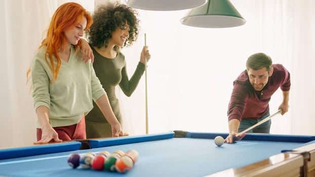 Photo of group of young friends smiling playing billiards