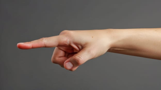 A person pointing at something with their finger on a gray background