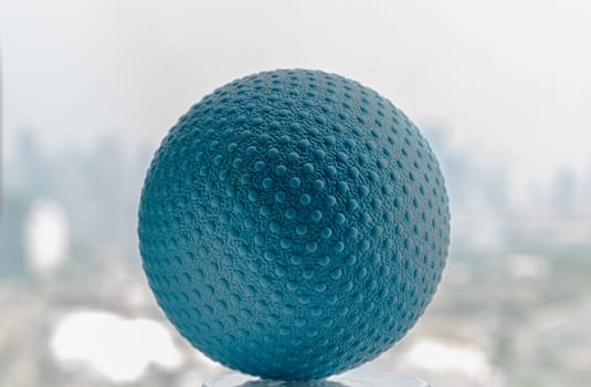 Lacrosse massage ball with blurred city background. Blue rubber lacrosse ball, Spherical ball, Space for text, Selective focus.