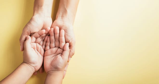 Symbolizing Family and Parents Day, Top view studio shot displays family hands stacked on an isolated background. Parents and kids hold an empty space signifying support and togetherness.