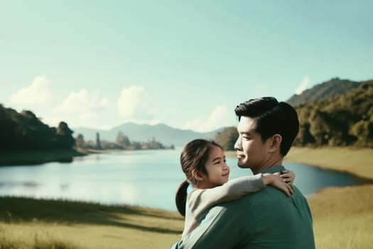 little daughter hugs her father on the shore of the lake,Father's Day concept