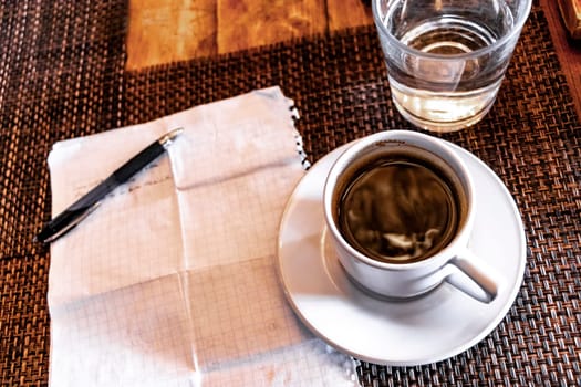 Cup of coffee with notepad and ballpoint pen on table in Playa del Carmen Quintana Roo Mexico.