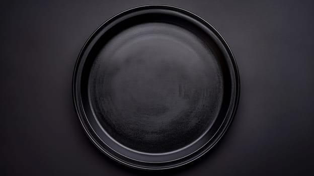 A black plate on a dark surface with no other objects