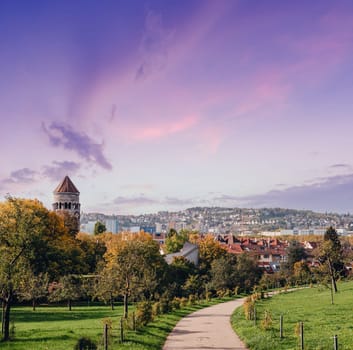 Germany, Stuttgart panorama view. Beautiful houses in autumn, Sky and nature landscape. Vineyards in Stuttgart - colorful wine growing region in the south of Germany with view over Neckar Valley. Germany, Stuttgart city panorama view above vineyards, industry, houses, streets, stadium and highway at sunset in warm orange light.