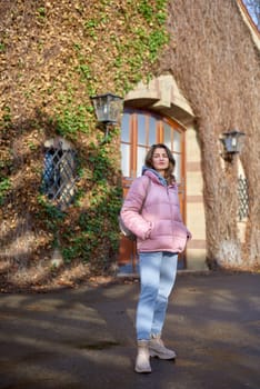 Young beautiful pretty tourist girl in warm hat and coat with backpack walking at cold autumn in Europe city enjoying her travel in Zurich Switzerland. Outdoor portrait of young tourist woman enjoying sightseeing