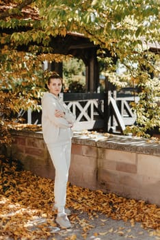 Beautiful elegant woman standing in a park in autumn. autumn yellow leaves. Portrait of joyful woman in park during fall. Happy girl with yellow leaves outdoor. Beauty Romantic Girl Outdoors enjoying nature. Beautiful autumn model with waving glow hair.Sun light on sunset.Warm toned art work. Portrait of romantic female