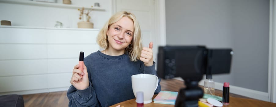 Young charismatic beauty blogger, teenage girl records video of her applying mascara, reviewing makeup products for her lifestyle vlog, vlogging for social media account.