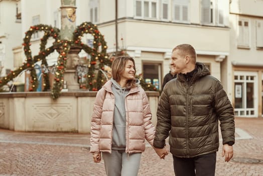 Loving couple of tourists walking around old town. Man woman couple walking europe old town Germany. Couple of lovers leisurely stroll in the cool autumn morning on the streets of a BIETIGHEIM-BISSINGEN (Germany). The guy holds his wife. Vacation, autumn, holiday. Couple Walking in Europe's Old Town