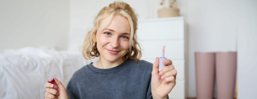 Portrait of young beautiful woman, content maker creating a new vlog, beauty video, showing lipstick, recommending makeup, records a tutorial.