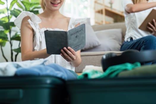 Young woman check baggage lists on notebook to prepare for traveling trip.