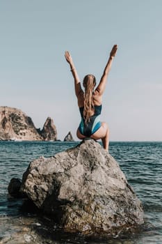 Woman beach vacation photo. A happy tourist in a blue bikini enjoying the scenic view of the sea and volcanic mountains while taking pictures to capture the memories of her travel adventure