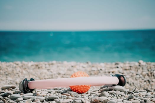 Young woman with long hair in white swimsuit and boho style braclets practicing outdoors on yoga mat by the sea on a sunset. Women's yoga fitness routine. Healthy lifestyle, harmony and meditation