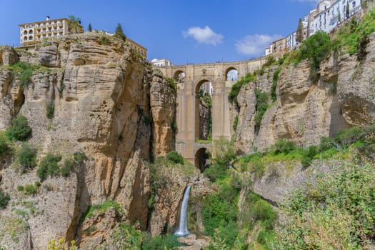 ronda ,malaga, spain 04/18/2023 new bridge over the cliff with a waterfall of the river guadalevin