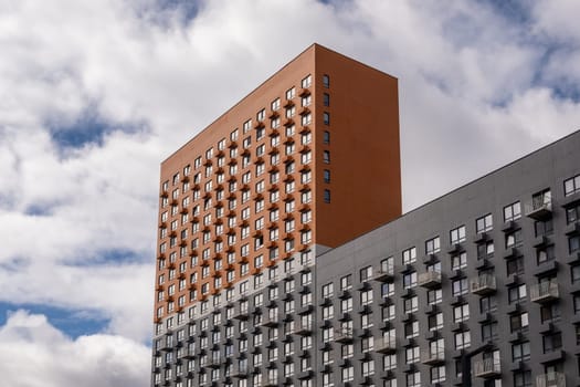 Residential complex in Moscow. New buildings in Moscow, high-rise bright creative house and against the sky. There are many apartments with Windows.