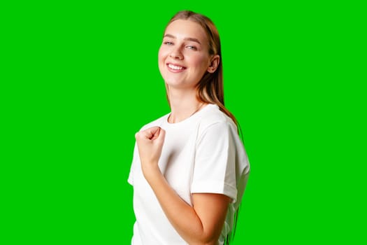 Happy Young Woman Raising Fists against green background in studio