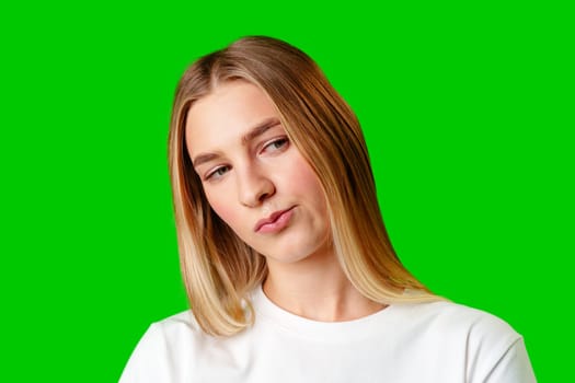 Young Woman With Pursed Lips Expressing Skepticism Against Green Screen Background in studio